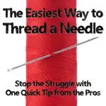 spool of red thread with a large silver needle stuck in the center with text overlay The easiest way to thread a needle