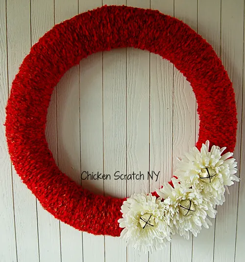 Decorate a festive holiday yarn wreath with reassembled jingle bell flowers