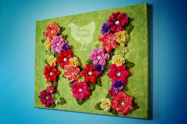 Decorate you walls with a bright and lively DIY Floral Monogram crafted on stretched canvas with fancy scrap booking brads
