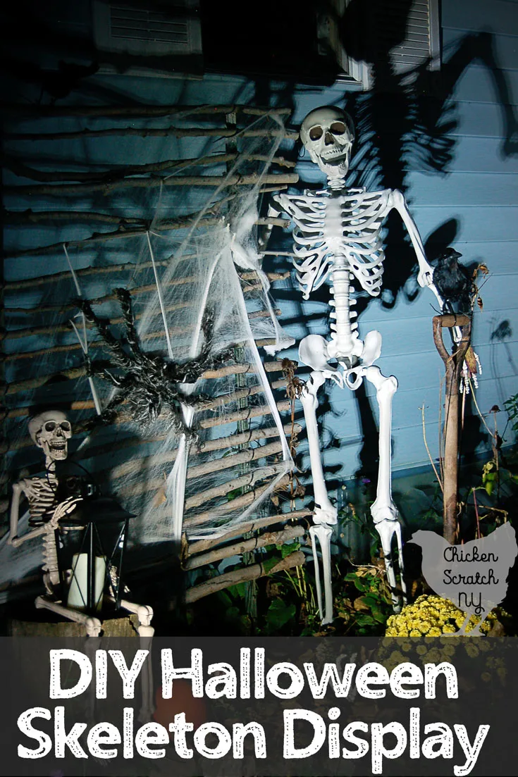 halloween skeleton display with life sized skeltion standing with shovel and crow, small skeleton sitting with lantern and skeleton hand sticking our of leaf pile by yellow mum