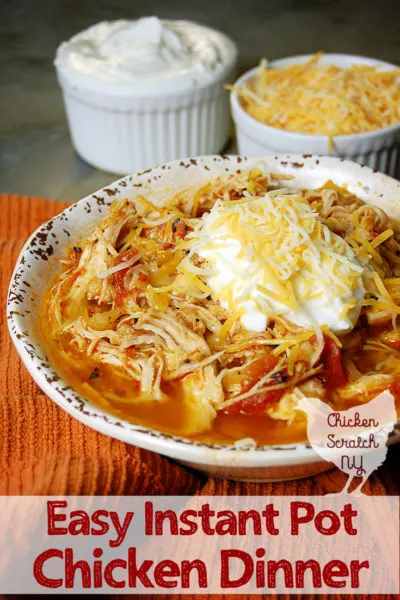 white bowl filled with instant pot chicken dinner with tomatoes and pineapple on an orange towel with two small white bowls filled with shredded cheese and greek yogurt