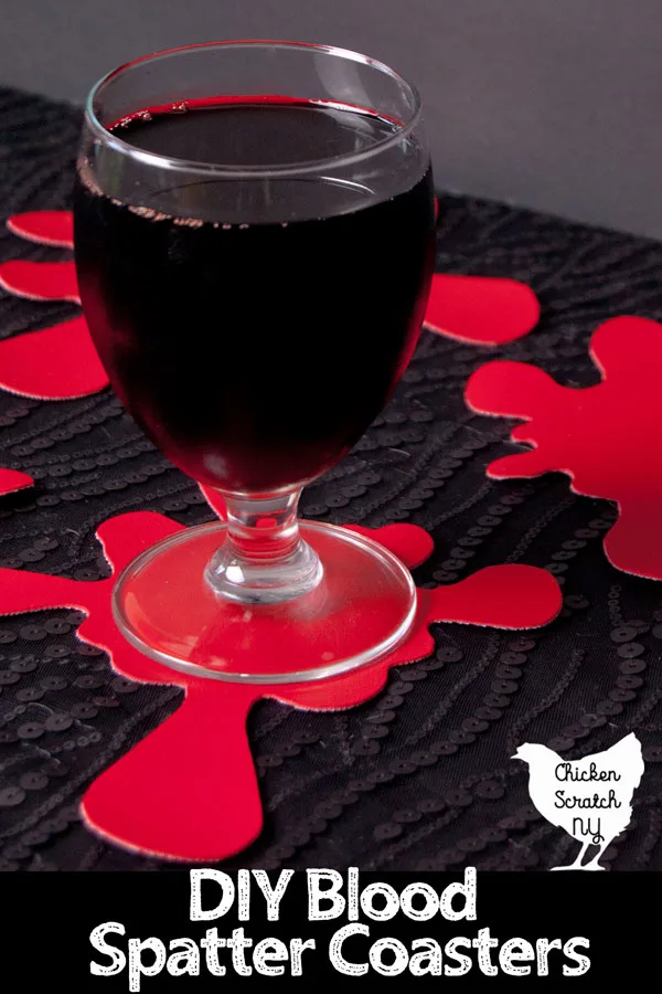 glass of red juice on a red vinyl hand made coaster shaped like a blood splatter