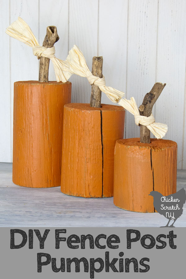three pieces of round fence post painted orange with sticks glued to the top to make fence post pumpkins