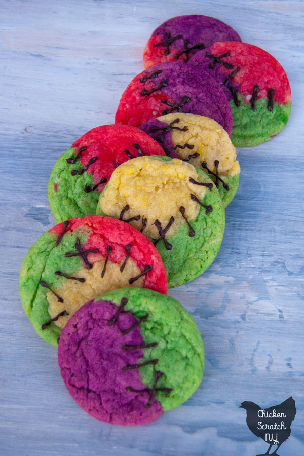 multi colored sugar cookies 'stitched' together with fake chocolate stitched to look like Sally's dress from The Nightmare Before Christmas on a whitish blue wooden background