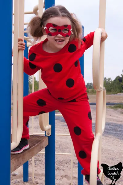 young girl in homemade miraculous ladybug costume on a playground