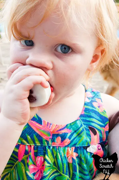 little blonde girl eating red velvet oreo truffle