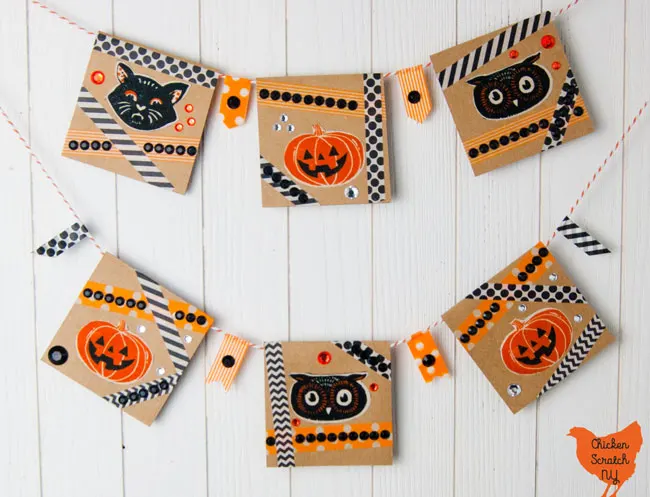 six card Halloween banner with vintage pumpkin, cat and owl faces with orange and black washi tape cross crossed around the Halloween shapes and orange, black and clear rhinestones 