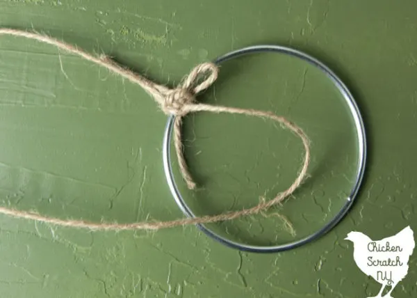 metal ring with twine tied to it to make a macrame half knot