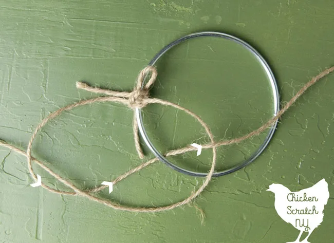 metal ring with twine tied to it to make a macrame half knot