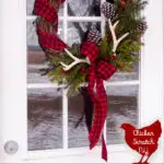 rustic farmhouse country wreath made with buffalo check ribbon, pine cones, antlers and faux greenery