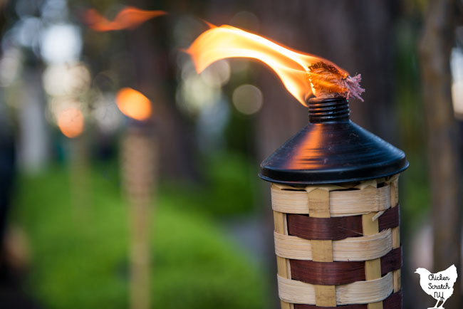 bamboo tiki torch lit in a garden