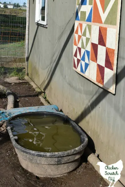 filled water tub next to barn quilt