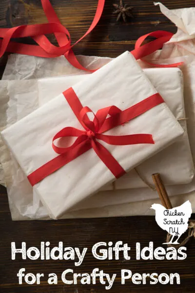 white gift box tied up with red ribbon , text overlay holiday gift ideas for a crafty person