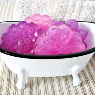 bath tub shaped soap dish filled with pink and purple floral m&p soaps with holographic glitter