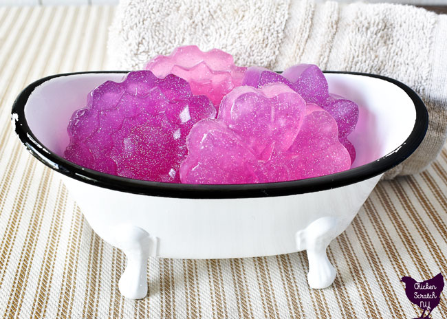 bath tub shaped soap dish filled with pink and purple floral m&p soaps with holographic glitter