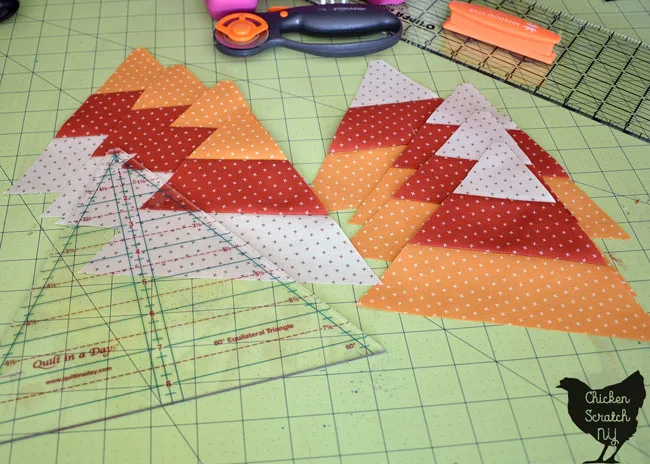 cut 60 degree candy corn triangles in two piles with a 60-degree ruler and rotary cutter on a rotary mat