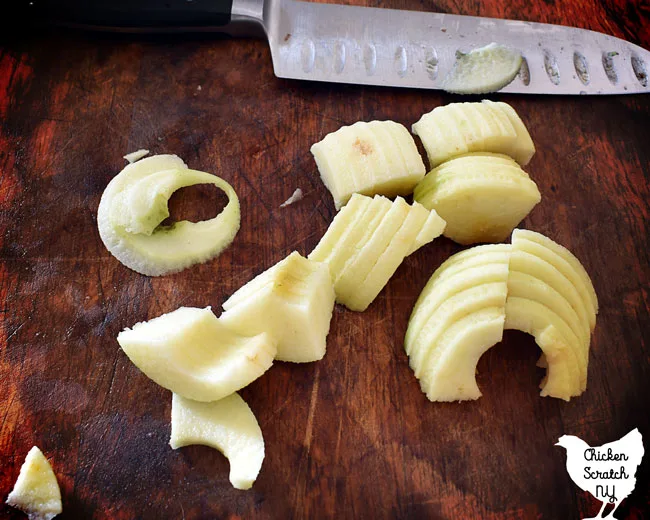 cut apples on a cutting board with a large kitchen knife