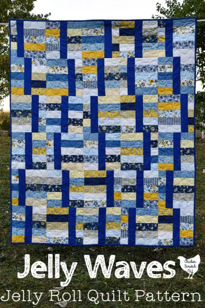 yellow and blue Jelly Waves quilt made with 2 1/2 inch strips hanging on a clothes line