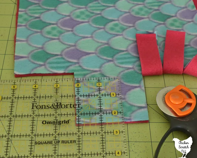 use the rotary cutter, mat and ruler to cut 1 inch wide slits all around the blanket