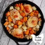 top view of lodge cast iron skillet filled with roasted onions, sweet potatoes, white potatoes and chicken thighs
