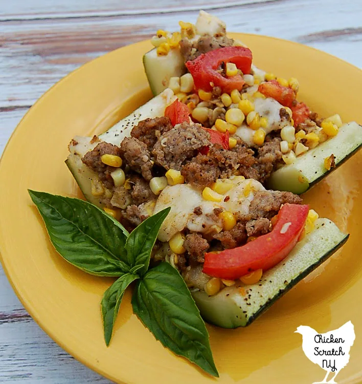 view of stuffed zucchini filled with fresh sweet corn, chopped tomatoes, mozzarella and sausage