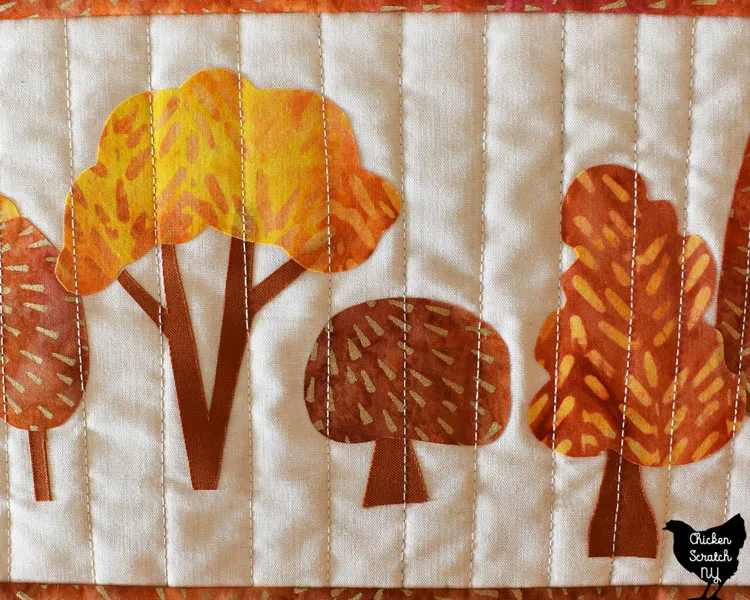 close of of finished fusible appliw autumn tree table runner with straight line stitching