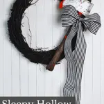 sleepy hollow inspired Halloween wreath with a bloody axe and a black and white striped ribbon