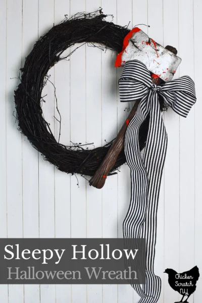 sleepy hollow inspired Halloween wreath with a bloody axe and a black and white striped ribbon