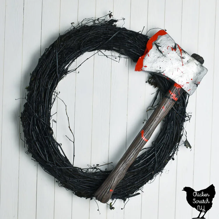 black grapevine wreath with bloody axe on it