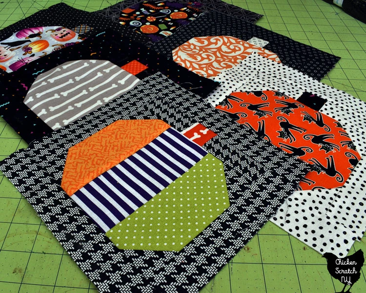 stack of pumpkin quilt blocks made with scraps of Halloween fabric