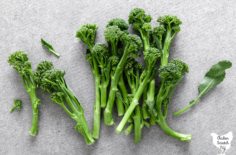 broccolini florets on a stone surface