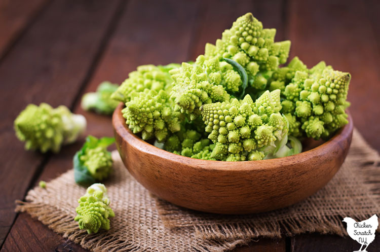 wooden bowl filled with green Romanesco broccoli florets