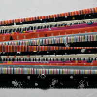 cut, pressed and stacked sections of Jelly Roll strips ready for scrappy binding