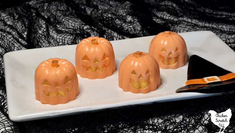 white plate with witch hat decoration holding 4 pumpkin soaps made with white melt and pour soap base