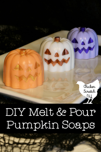 three pumpkin melt and pour soaps made in orange, white and purple with metallic faces