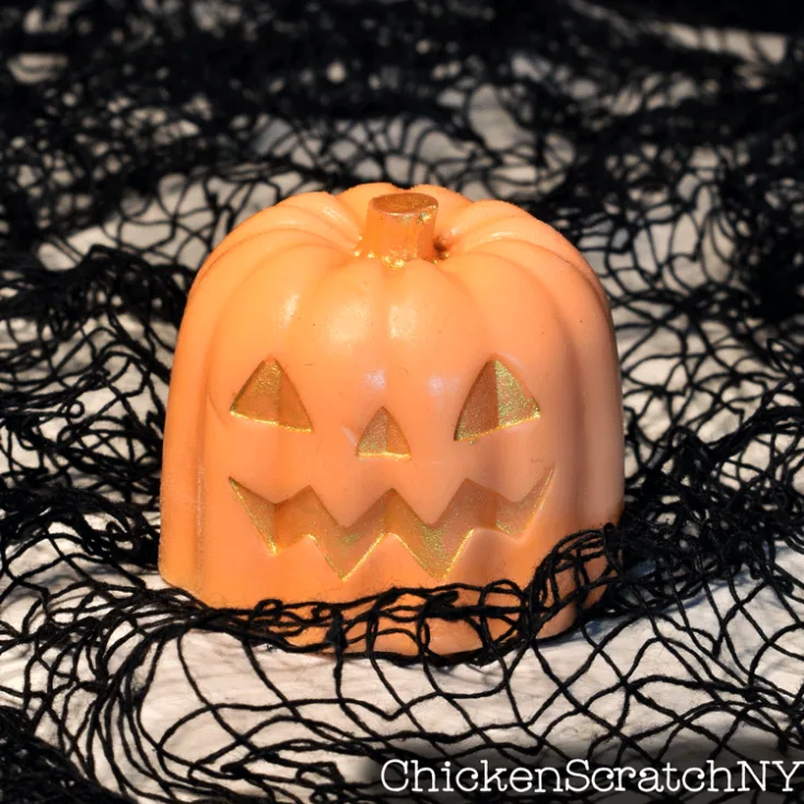 close up of single orange pumpkin soap with gold mica face