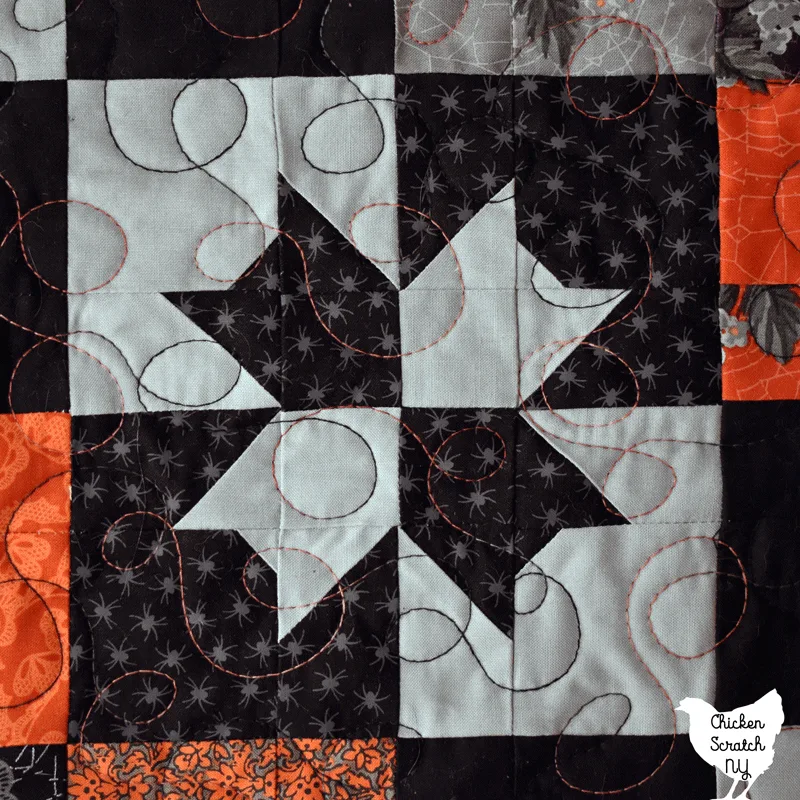 close up of Charm Pack Crispies quilt block showing loopy meander free motion quilting with variegated thread Cold Lava from Valdani 