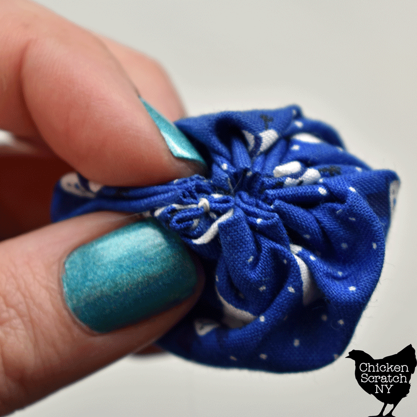 hide the knot in a fabric yoyo by making it inside the pleats