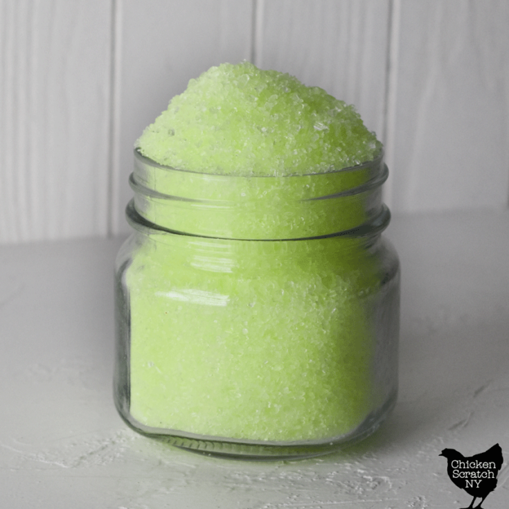 glass jar filled to over flowing with lime green bath salts