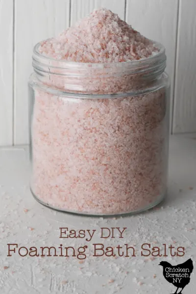 large glass jar filled with tan brown bath salts with text overlay "easy DIY foaming bath salts"