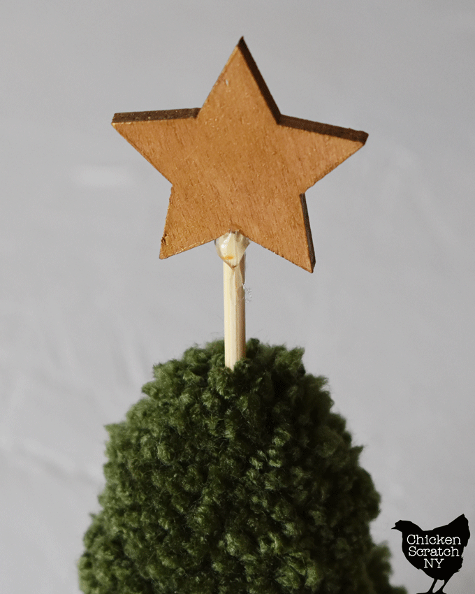 use hot glue to attach the star to the top of the tree